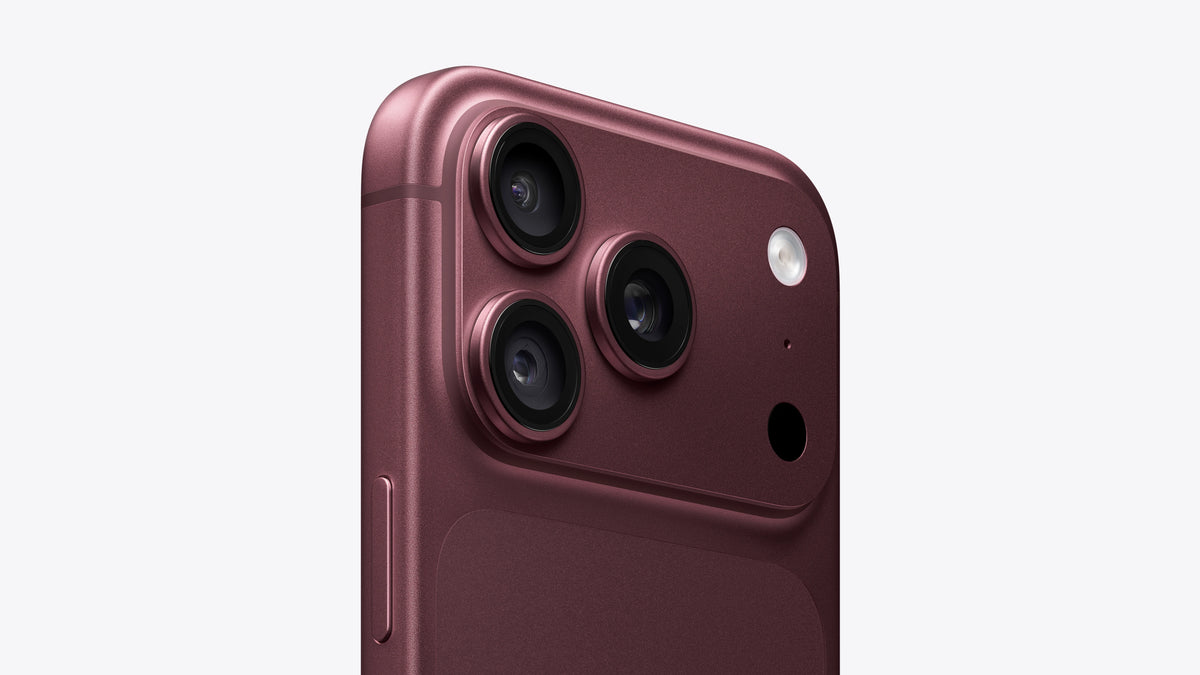 Close-up of the rear upper portion of a smartphone in a metallic rose-gold finish, showing three rear cameras, a flash, and a small circular cutout on a light gray background.