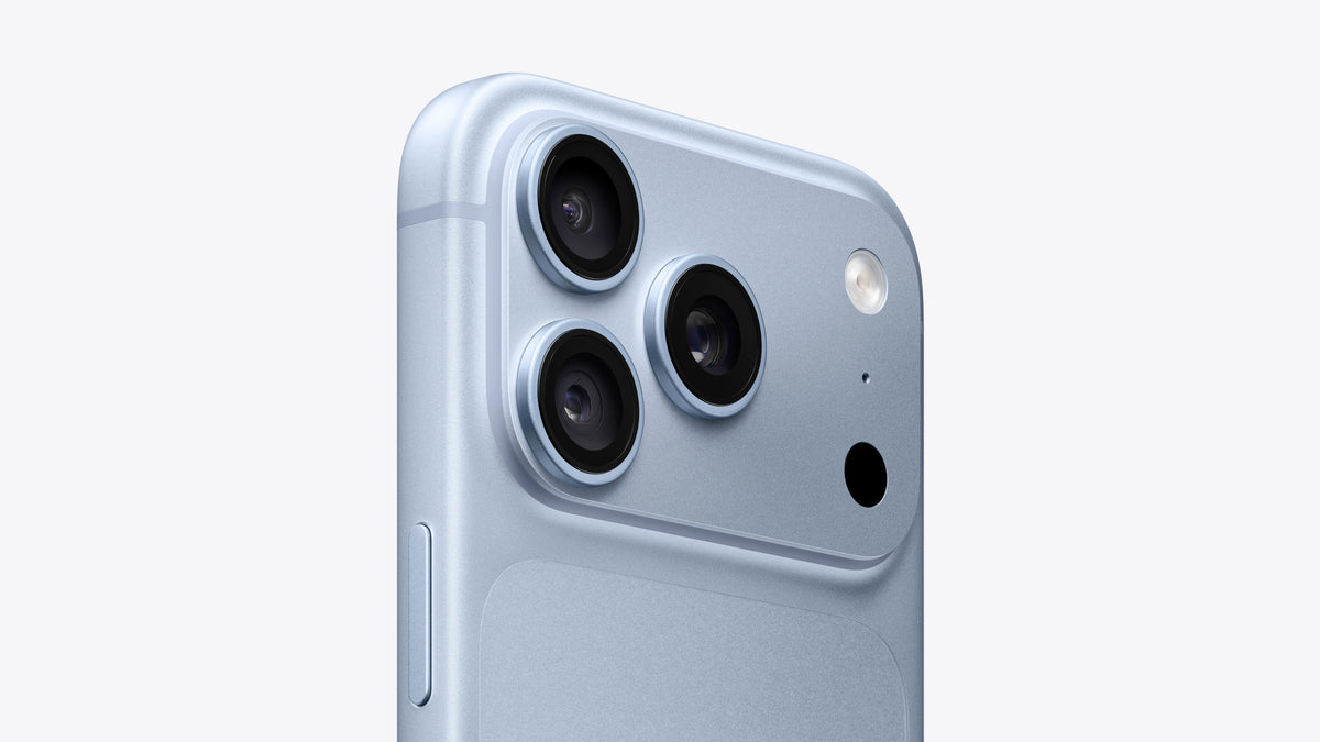Close-up of the back corner of a light blue smartphone showing a triple-camera system and flash on a clean white background.