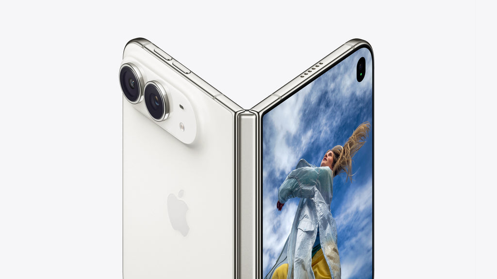 A white Apple foldable smartphone shown open at an angle, with the back panel visible on the left and the inner display showing a person outdoors on the right. The Apple logo is visible on the back.